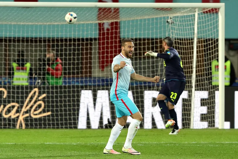 Penyerang Turki bersorak mengepalkan tangan di depan gawang sementara kiper Austria berbalik di belakangnya