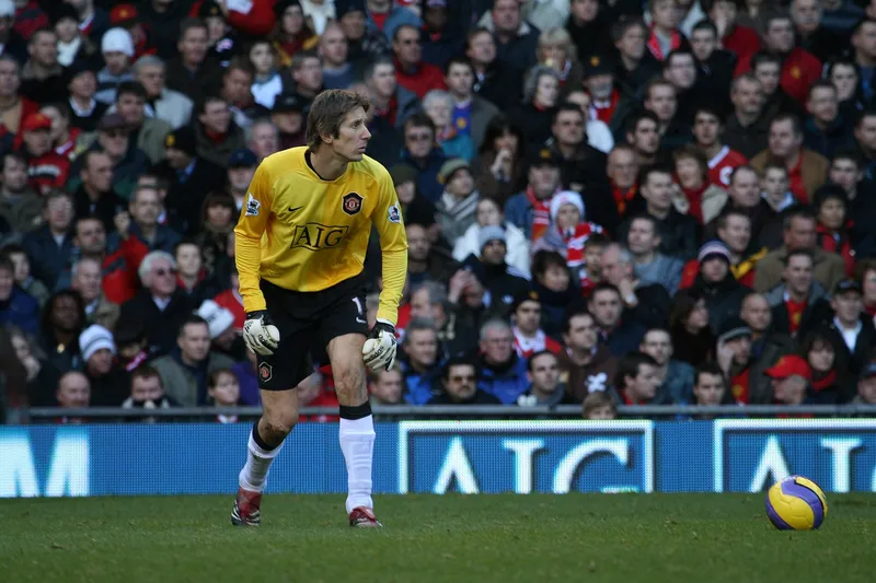 Kiper Manchester United Edwin van der Sar berkaus kuning bersiap di lapangan dengan bola di dekatnya