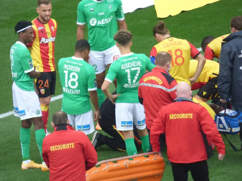 Petugas medis merawat pemain Lens yang cedera di lapangan