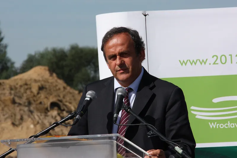 Michel Platini berbicara di podium dengan beberapa mikrofon
