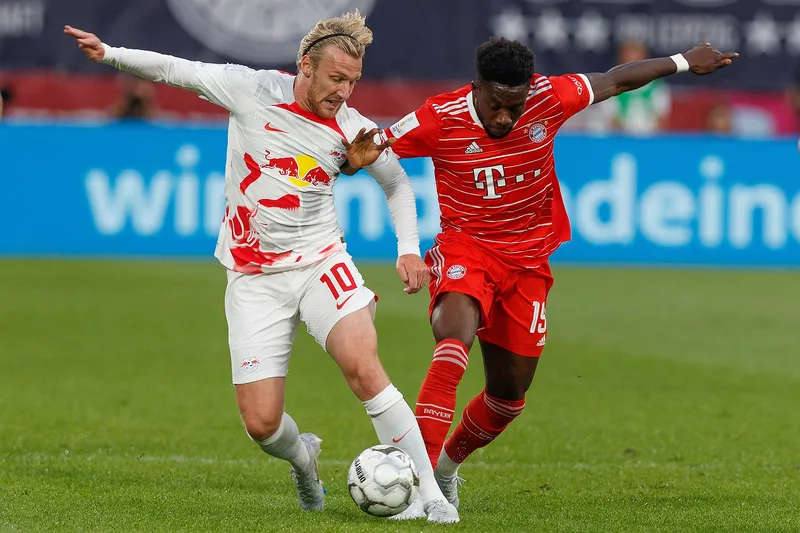 Alphonso Davies berduel memperebutkan bola dengan Emil Forsberg dari RB Leipzig