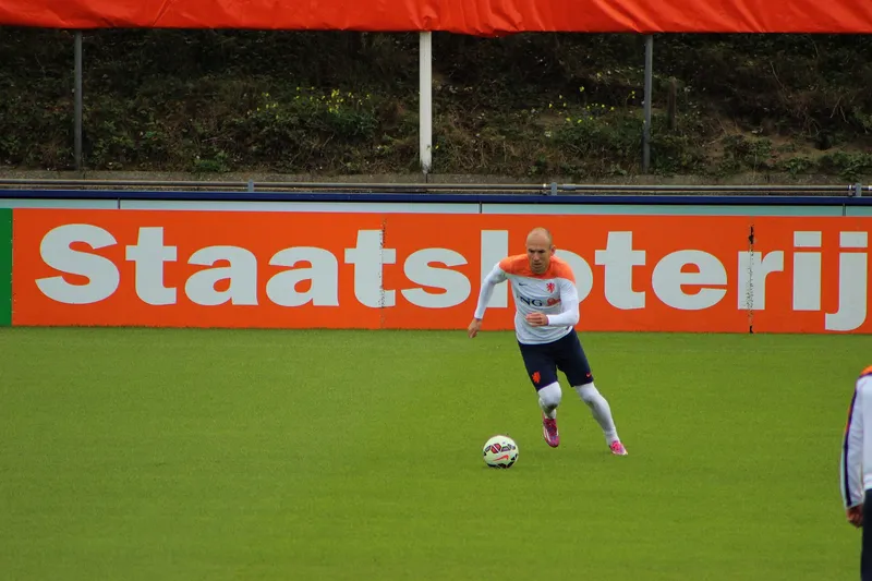 Arjen Robben berkaus latihan oranye putih menggiring bola di lapangan latihan tim nasional Belanda