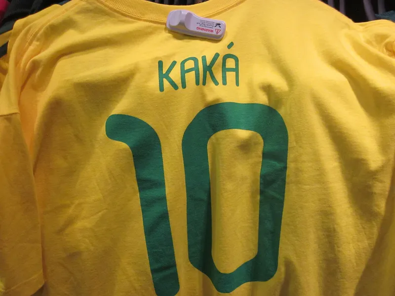 Bagian belakang jersey kuning Brasil bertuliskan KAKÁ dan nomor 10 berwarna hijau