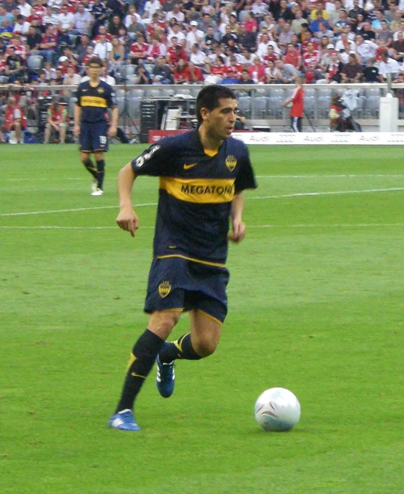 Juan Roman Riquelme berseragam biru kuning Boca Juniors menggiring bola di lapangan