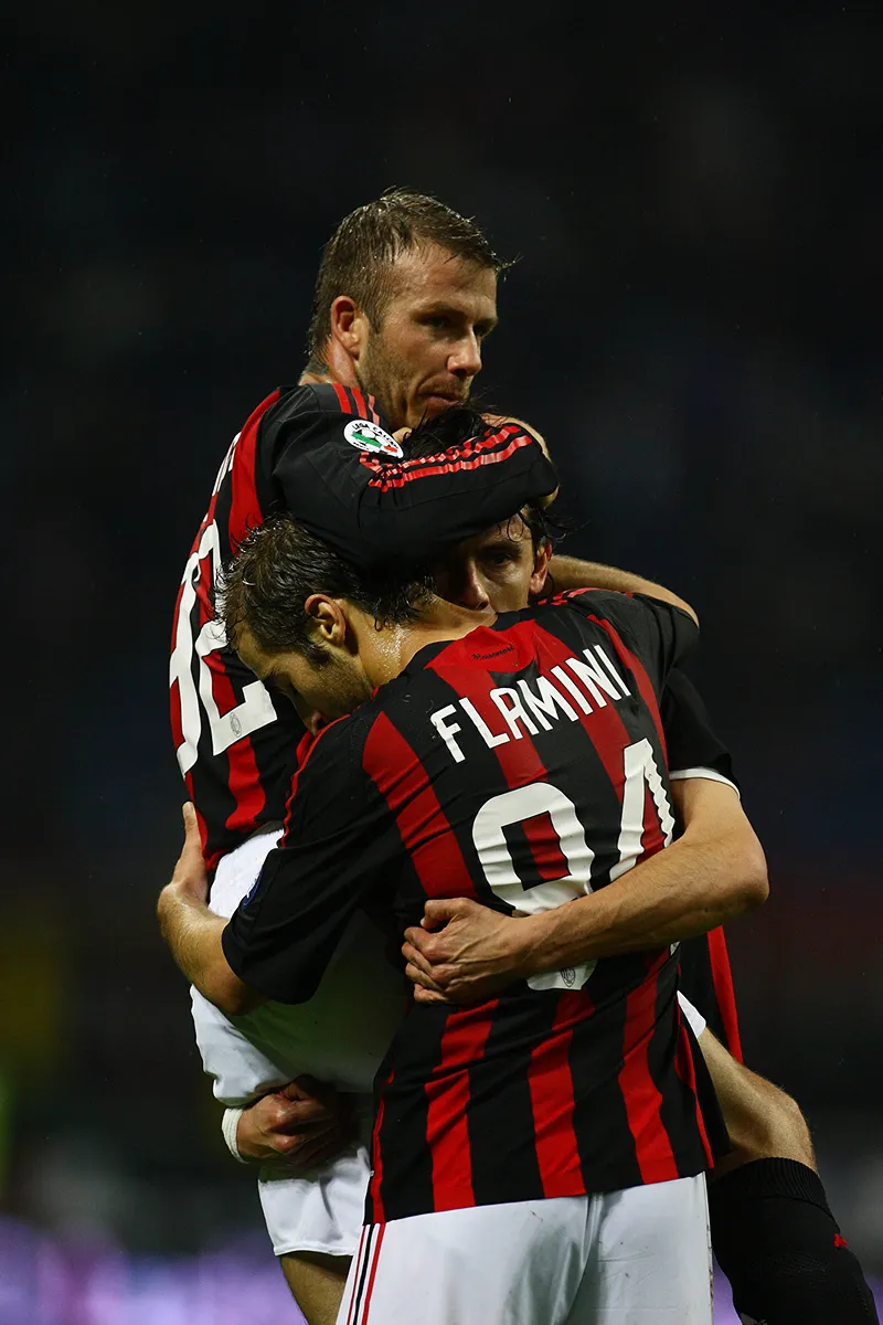 David Beckham dan Mathieu Flamini memeluk Filippo Inzaghi dalam seragam merah hitam AC Milan