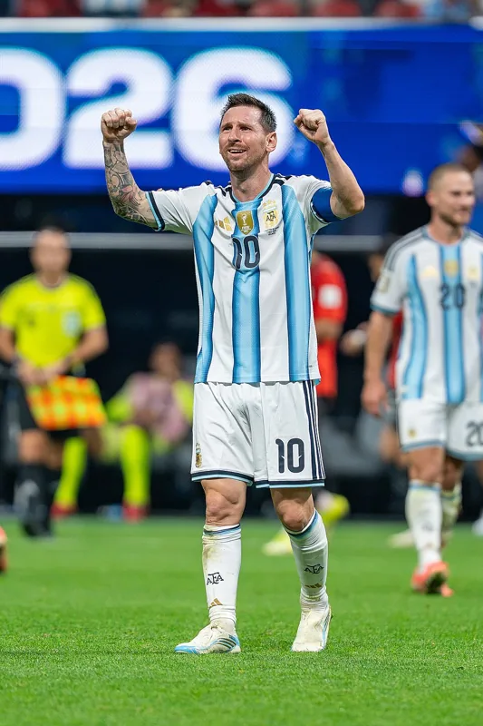 Lionel Messi mengangkat kedua kepalan tangan dengan seragam Argentina nomor 10.