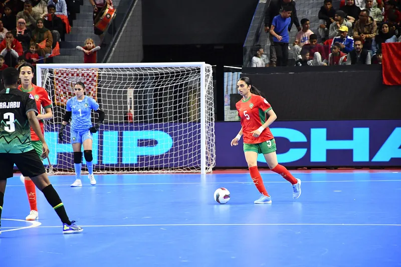 Pemain futsal putri Maroko bernomor 5 membawa bola di lapangan indoor saat final melawan Tanzania