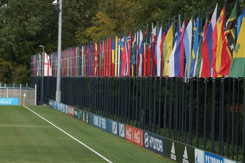Deretan bendera negara anggota FIFA di samping lapangan kompleks Home of FIFA