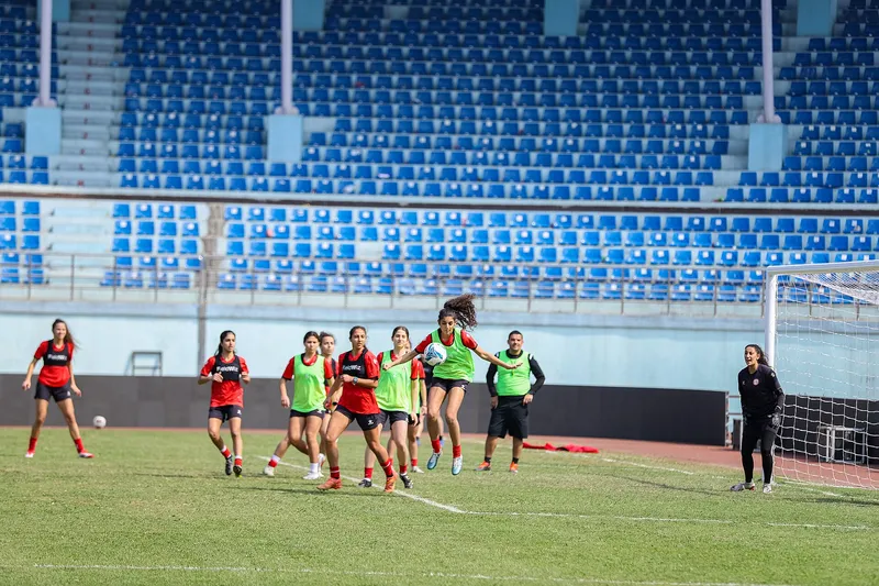Pemain timnas putri Lebanon berompi hijau dan berkaos merah berebut bola dalam permainan latihan di stadion