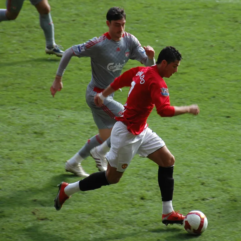 Albert Riera dari Liverpool berlari mengejar Cristiano Ronaldo dari Manchester United yang menggiring bola