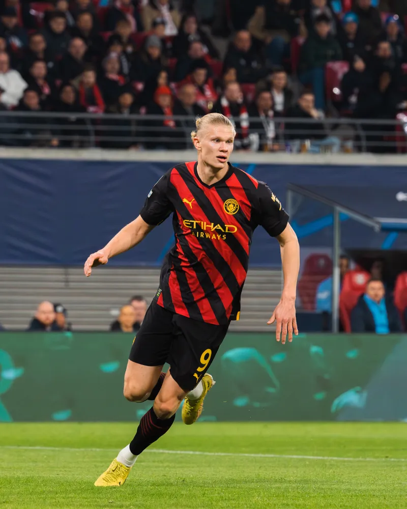 Erling Haaland berseragam Manchester City bernomor 9 berlari di lapangan saat laga Liga Champions