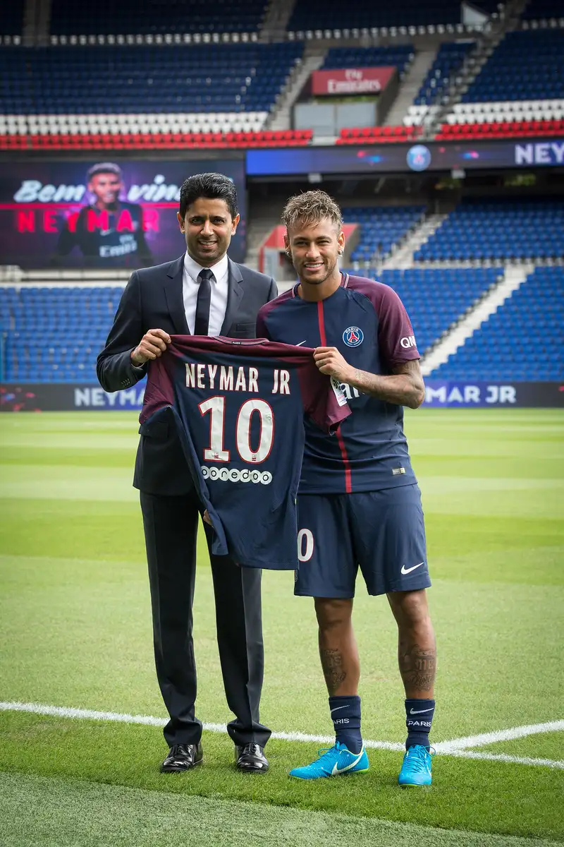 Neymar dan seorang petinggi klub memegang jersey Paris Saint-Germain bertuliskan Neymar Jr nomor 10 di lapangan Parc des Princes