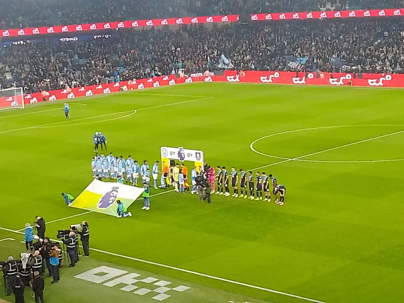Pemain Manchester City dan Burnley berbaris di lapangan sebelum laga Premier League dengan kru kamera siaran di pinggir lapangan