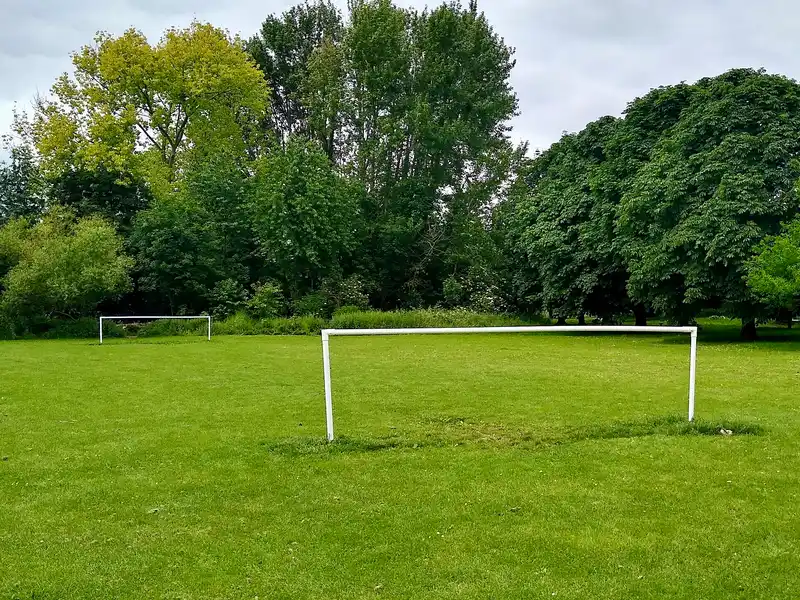 Dua gawang kecil tanpa jaring bergaya five-a-side di lapangan rumput taman