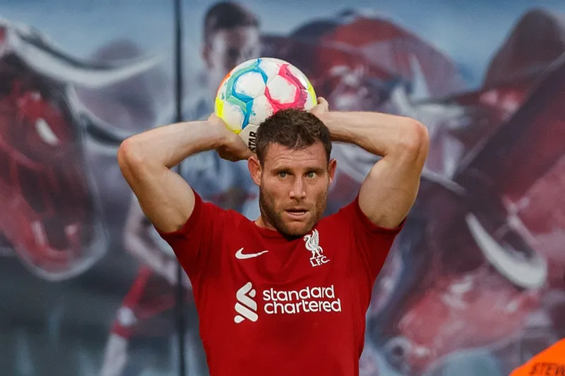 James Milner berseragam merah Liverpool bersiap melakukan lemparan ke dalam dengan bola di atas kepala